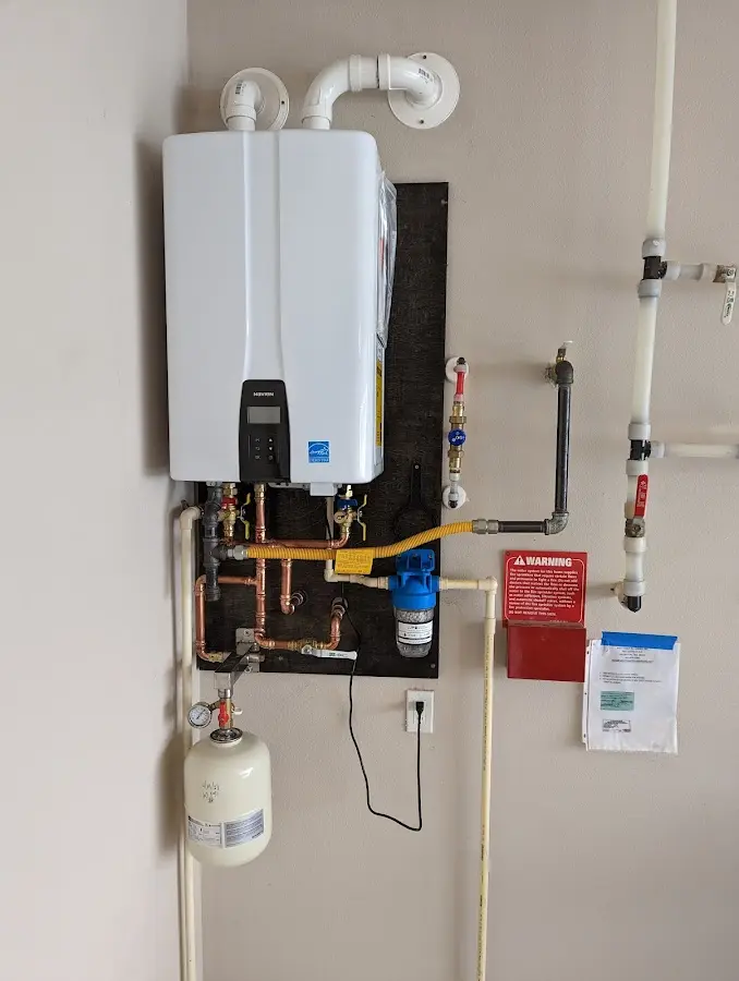 Professional plumber installing copper piping in a Landis home